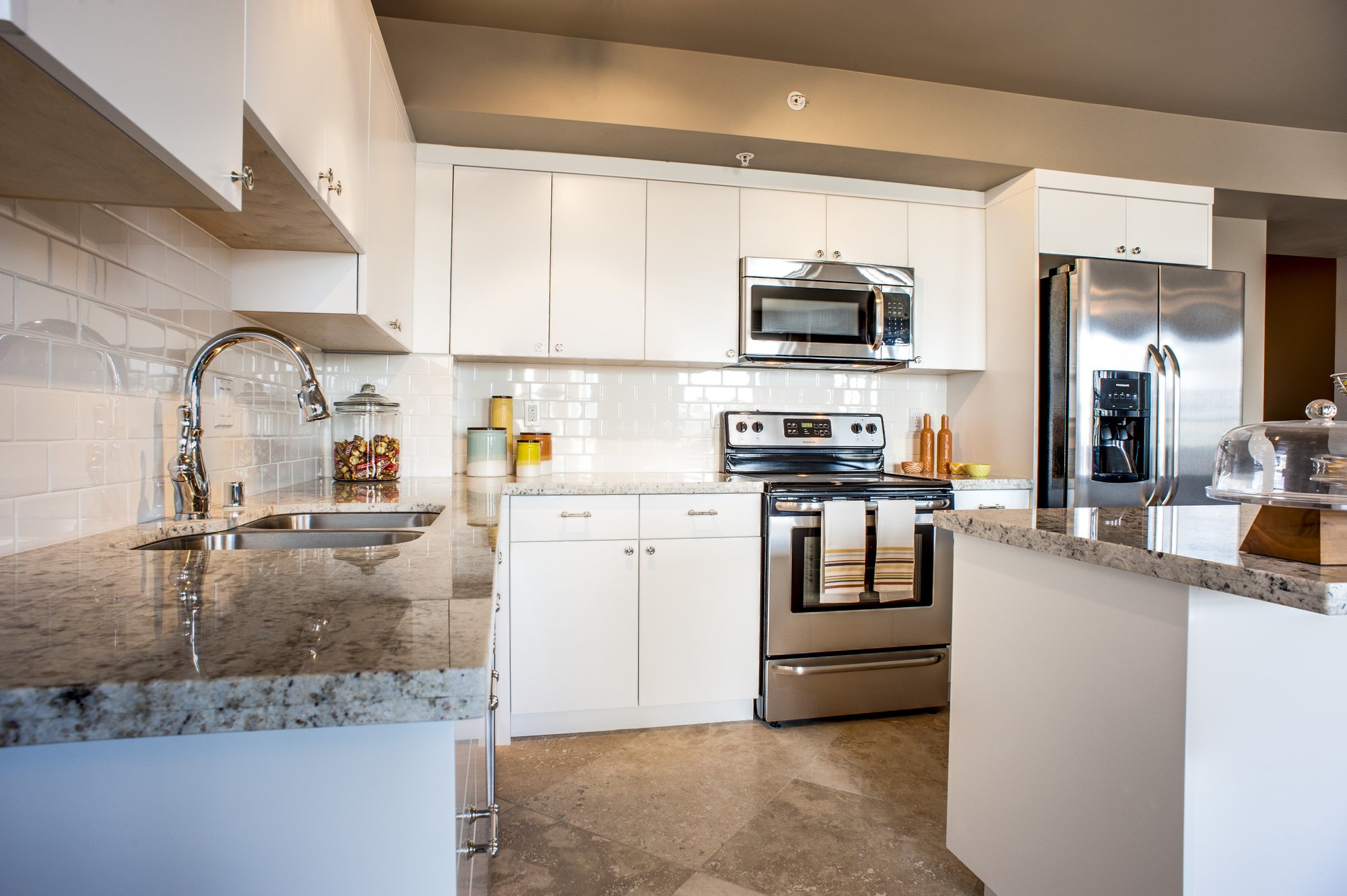 Renovated kitchen with white cabinets and granite counters at Walker Apartments
